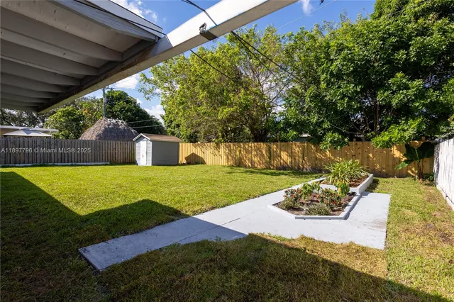 a view of a house with backyard and a tree