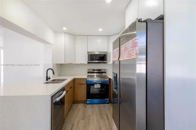 a kitchen with stainless steel appliances granite countertop a refrigerator a sink a stove and cabinets