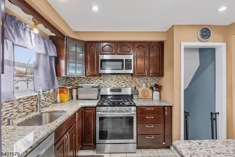 2563 Jackson Avenue Union, NJ 07083 - Photo 16 of 39 a kitchen with stainless steel appliances granite countertop a stove a sink and a microwave