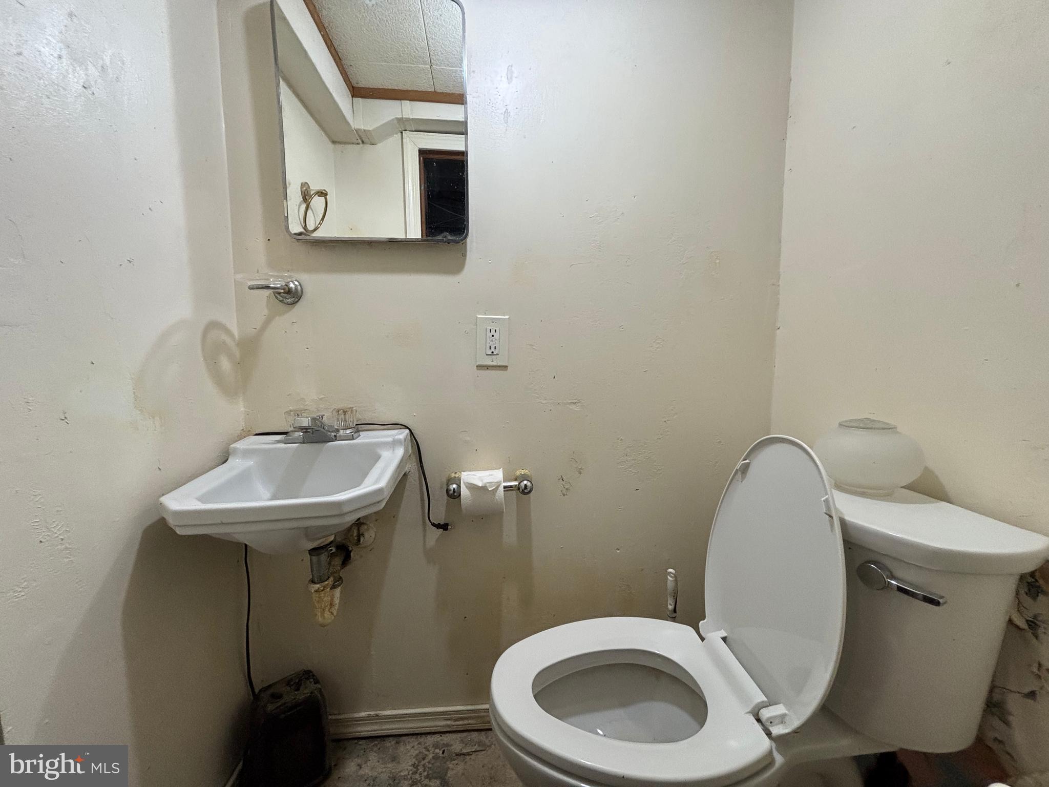 7552 Rabon Avenue Baltimore, MD 21222 - Photo 33 of 39 a bathroom with a toilet sink and mirror