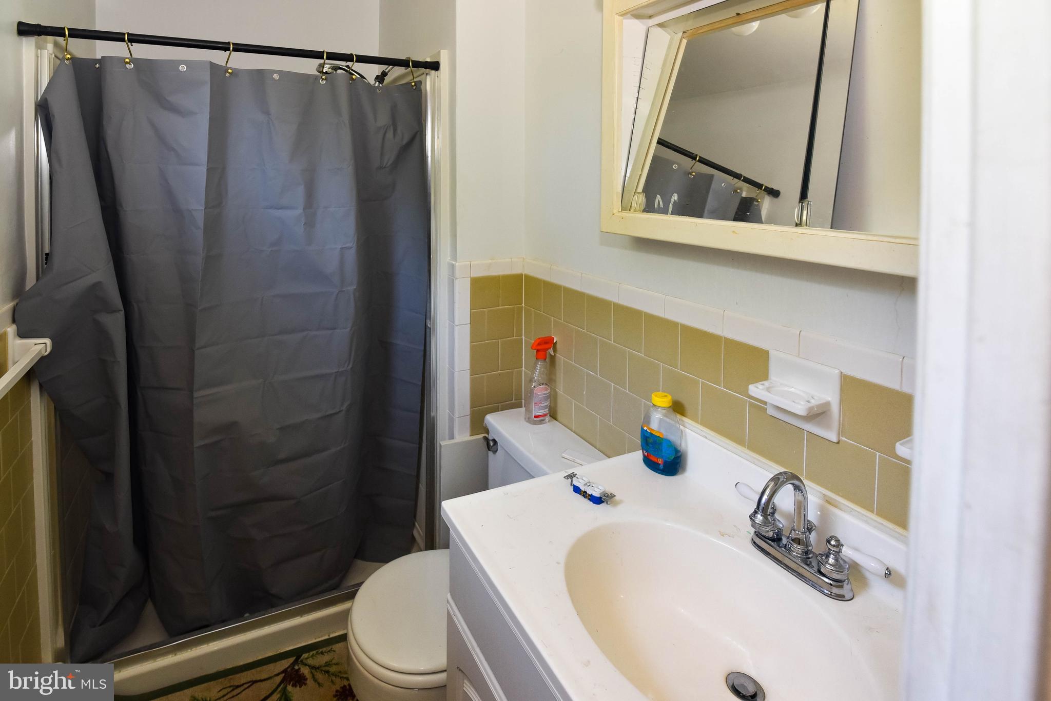 1204 Dicus Mill Road Millersville, MD 21108 - Photo 22 of 63 a bathroom with a sink a toilet and shower curtain