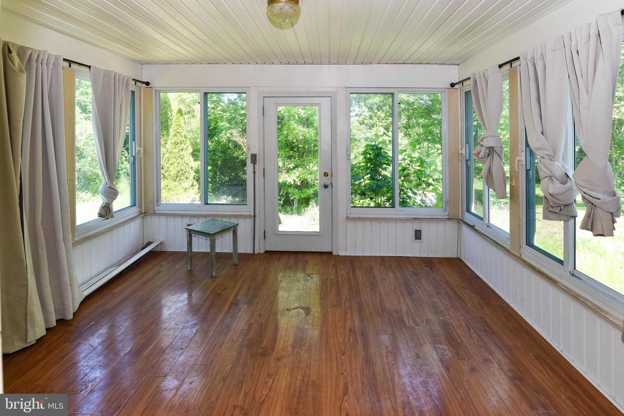 1204 Dicus Mill Road Millersville, MD 21108 - Photo 10 of 63 a view of an empty room with wooden floor and a window