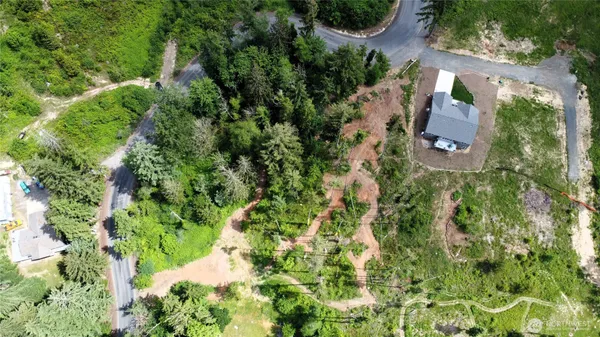 an aerial view of residential house with parking space and trees all around
