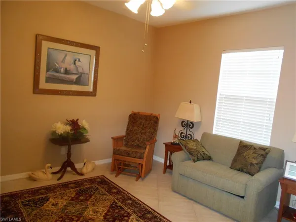 a living room with furniture a rug and a window