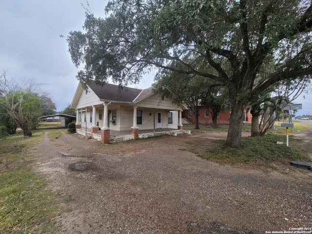 a front view of a house with yard and tree s