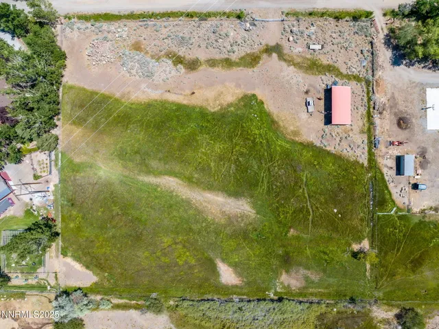 an aerial view of residential house with pool and trees all around