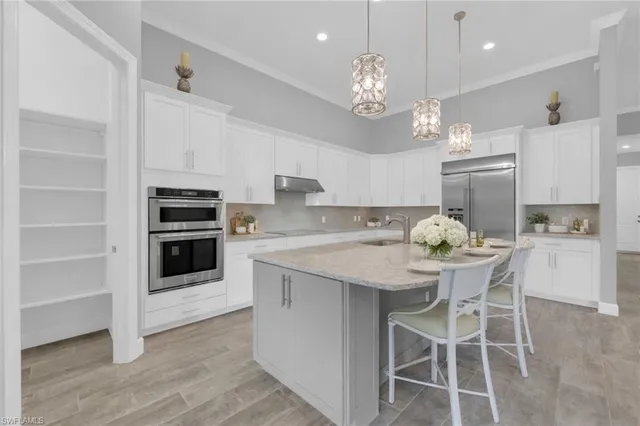 a kitchen with a dining table cabinets and stainless steel appliances
