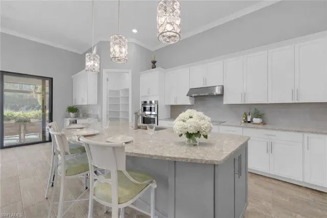 a kitchen with kitchen island granite countertop a table and chairs in it