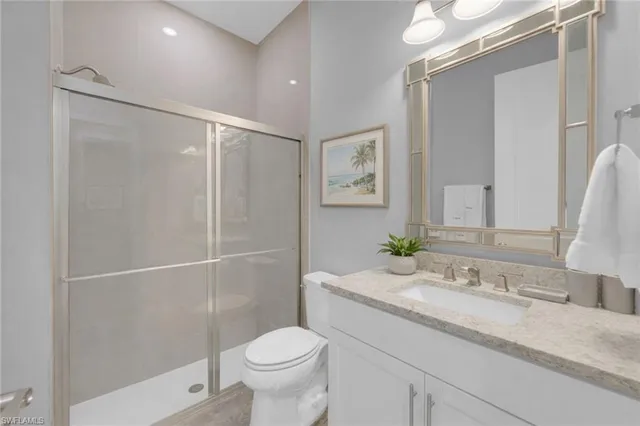 a bathroom with a granite countertop sink toilet and shower