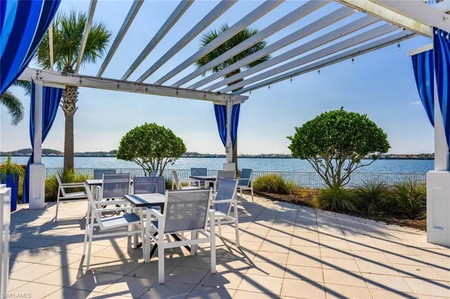 a view of a patio with table and chairs potted plants with wooden floor and fence