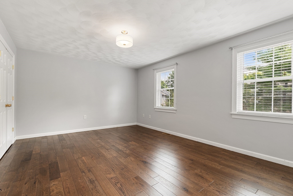 2 Ricciuti Drive, Unit 9 Quincy, MA 02169 - Photo 27 of 40 a view of an empty room with wooden floor and a window