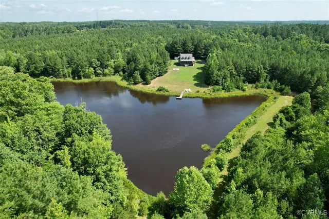 an aerial view of a house with a yard and lake view