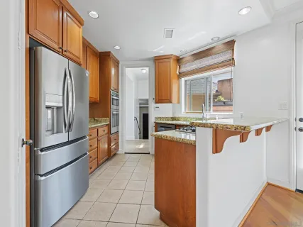 a kitchen with stainless steel appliances granite countertop a refrigerator and a sink