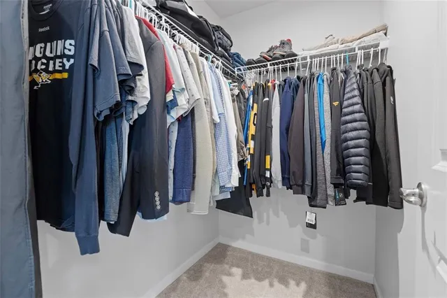 a view of walk in closet with clothes and shoes