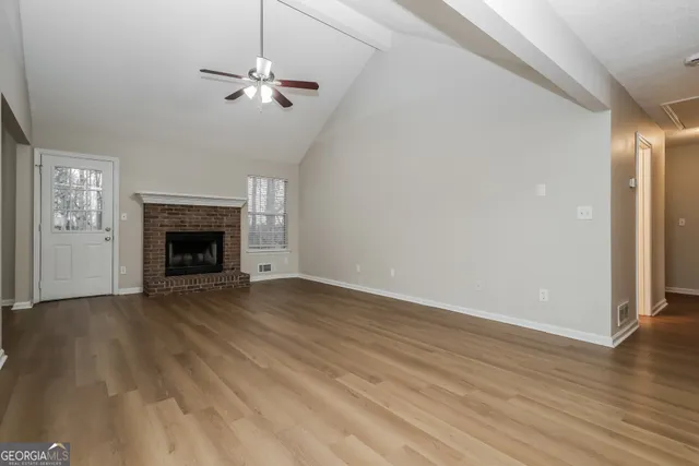 wooden floor fireplace and windows in an empty room