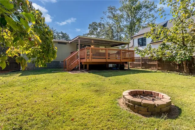 a backyard of a house with wooden fence and large trees