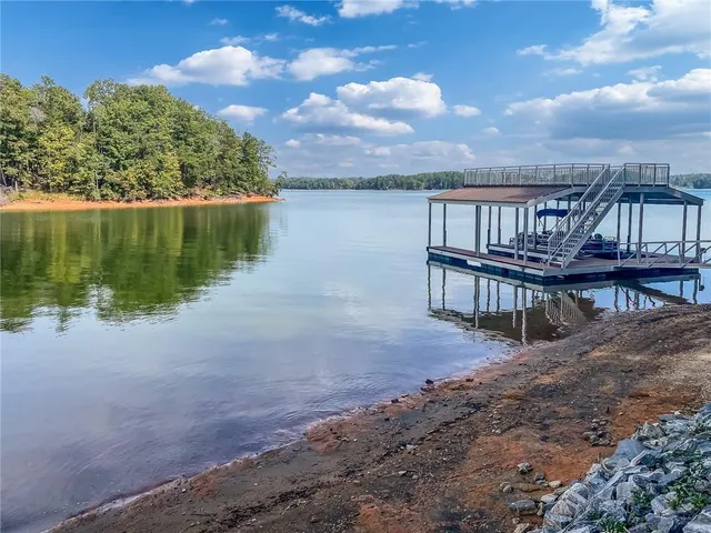 a view of a lake with a big yard and large trees