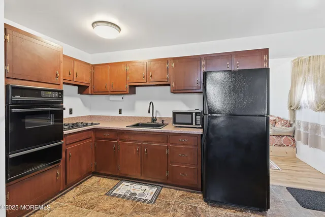a kitchen with stainless steel appliances granite countertop a refrigerator and a sink