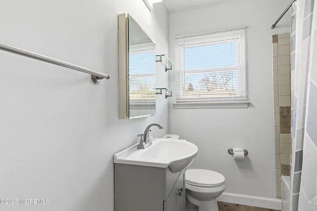 a bathroom with a toilet a sink a mirror and a shower
