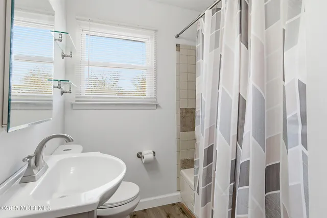 a bathroom with shower a sink and a toilet