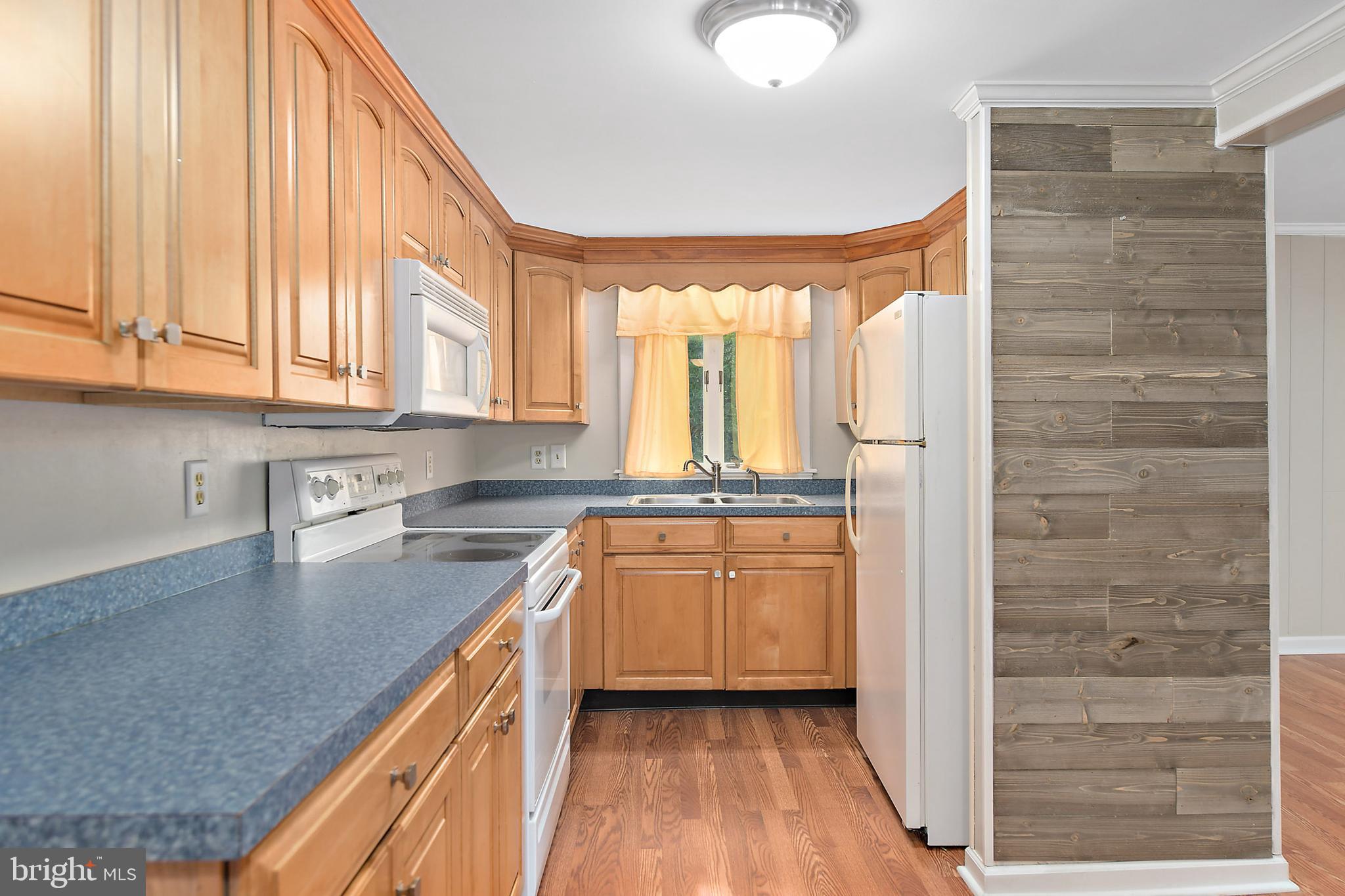 10826 Brownstone Road Princess Anne, MD 21853 - Photo 13 of 68 a kitchen with stainless steel appliances granite countertop a refrigerator a sink dishwasher and wooden cabinets with wooden floor