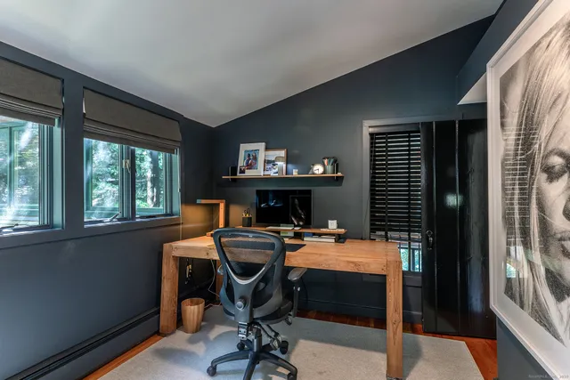 a view of a workspace with furniture and a window