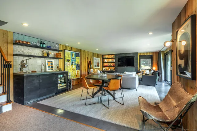 a living room with furniture a flat screen tv and kitchen view