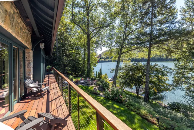 a balcony with wooden floor and outdoor seating