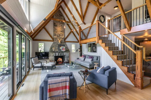 a living room with furniture a fireplace and a large window with wooden floor