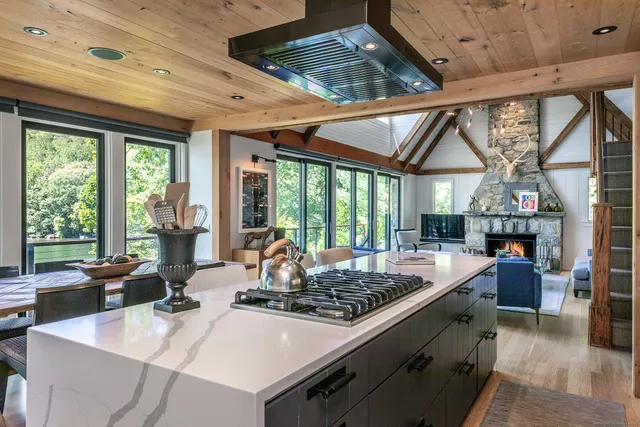 a kitchen with stove and large windows