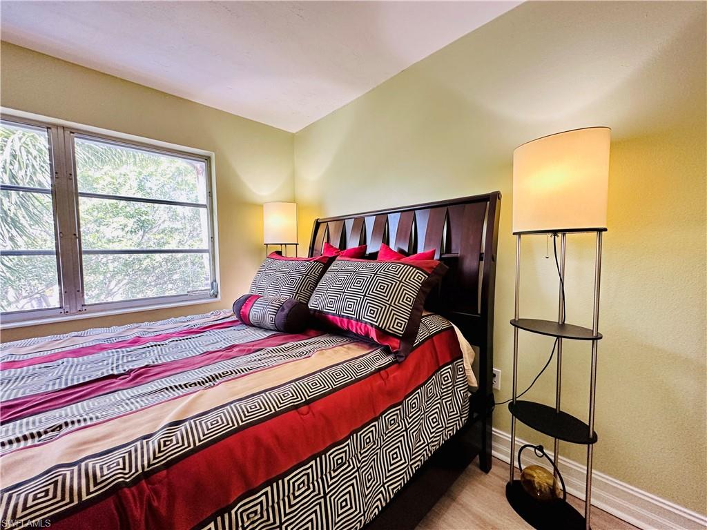 72 7th Street South, Unit 306 Naples, FL 34102 - Photo 19 of 23 a bedroom with a bed and a painting on the wall