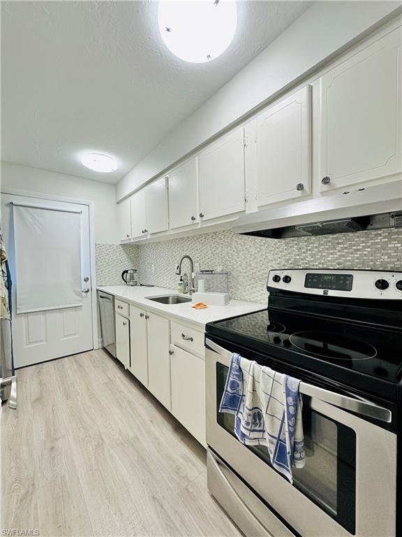 72 7th Street South, Unit 306 Naples, FL 34102 - Photo 9 of 23 a kitchen with a stove and white cabinets
