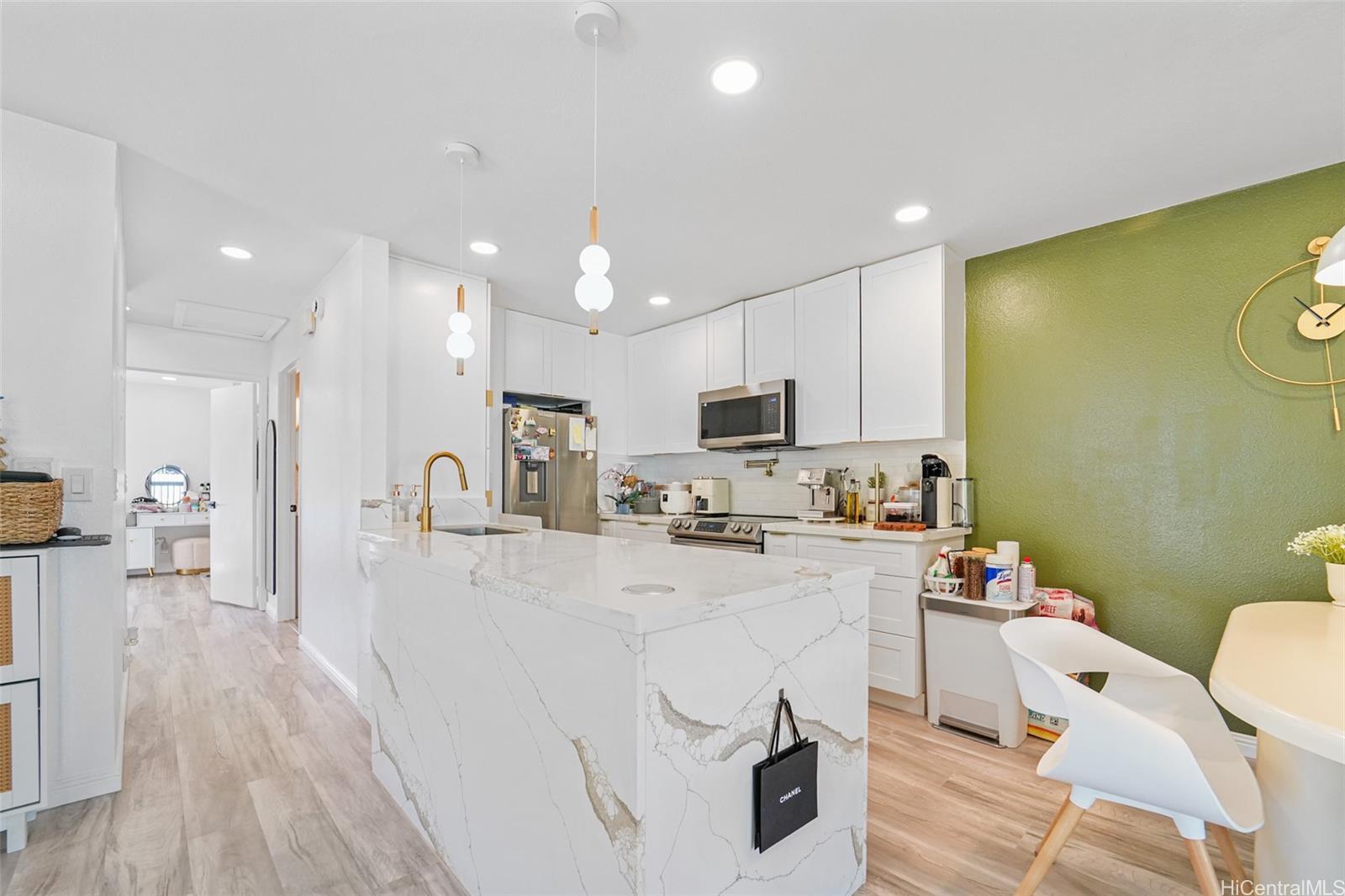 94-828 Lumiauau Street, Unit M204 Waipahu, HI 96797 - Photo 5 of 25 a living room with stainless steel appliances furniture a rug and a kitchen view
