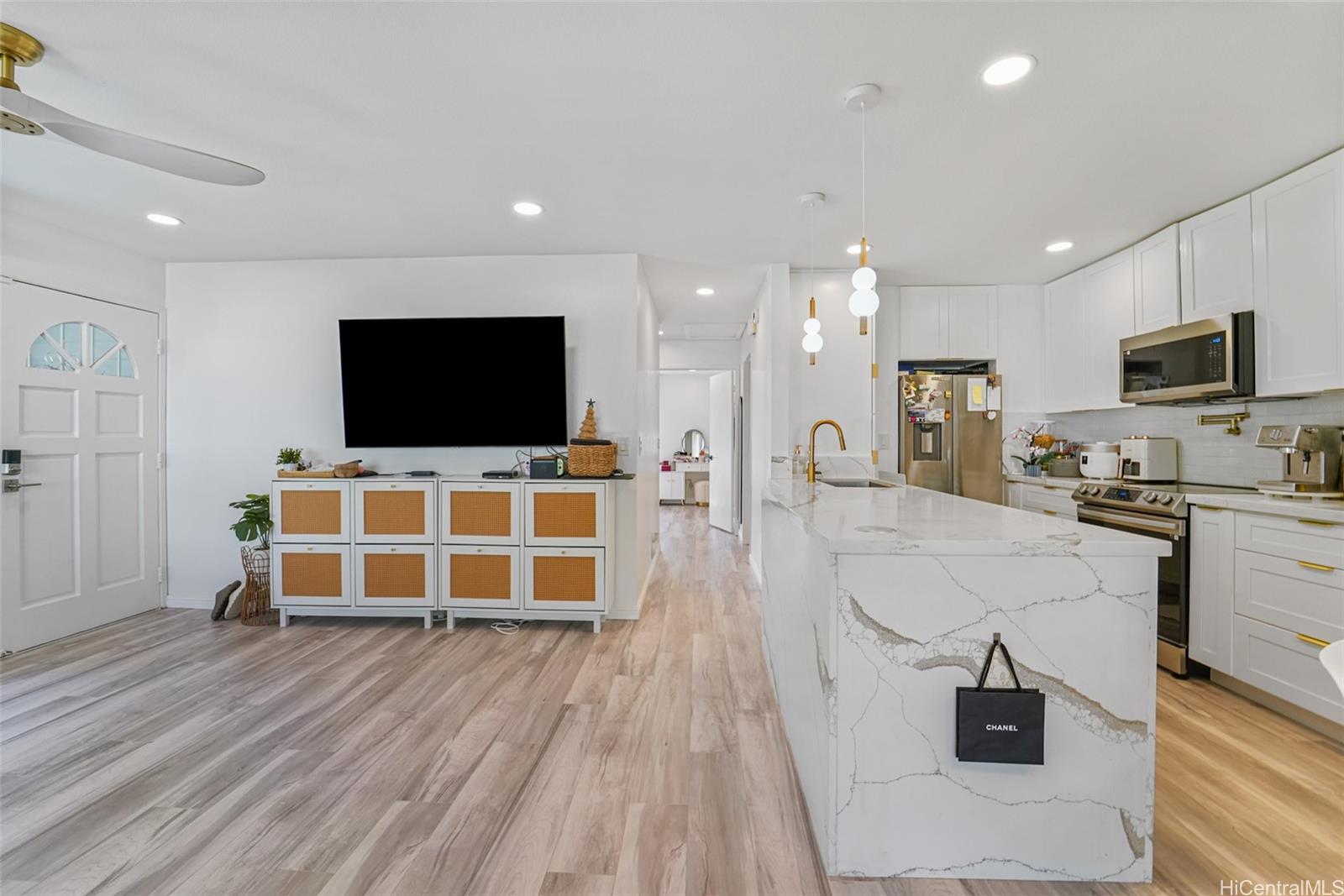 94-828 Lumiauau Street, Unit M204 Waipahu, HI 96797 - Photo 6 of 25 a living room with a flat screen tv and gym equipment