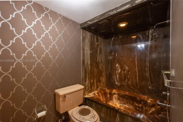 a bathroom with a toilet and a shower