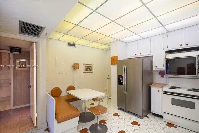 a kitchen with stainless steel appliances granite countertop a refrigerator and a stove top oven