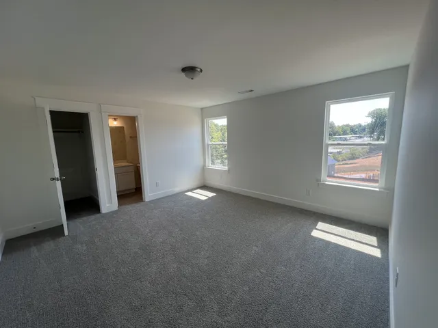 an empty room with windows and closet
