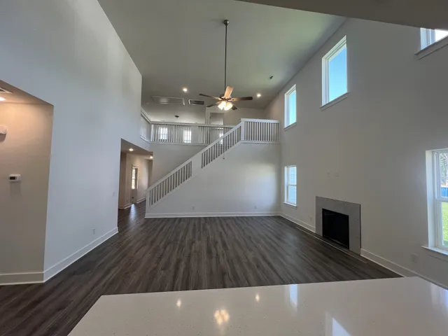 a view of a livingroom with wooden floor and staircase
