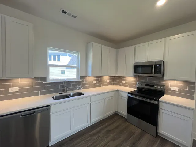 a kitchen with a sink stove and microwave