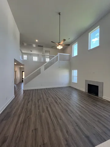 a view of a room with wooden floor staircase and a kitchen