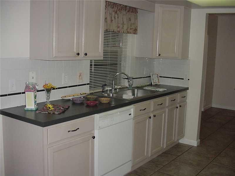 22729 Southwest 56th Avenue Boca Raton, FL 33433 - Photo 7 of 24 a kitchen with stainless steel appliances granite countertop a sink and cabinets