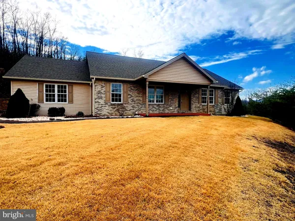 a front view of house with yard and trees in the background