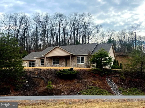 a front view of a house with a yard and trees