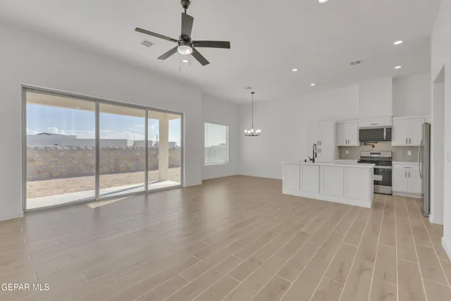 a view of a kitchen with a sink and dishwasher a refrigerator with wooden floor