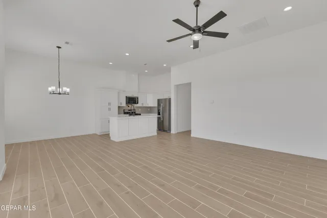 a view of a kitchen with kitchen island a sink wooden floor and living room view