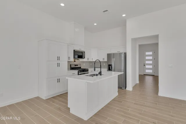 a kitchen with refrigerator and cabinets