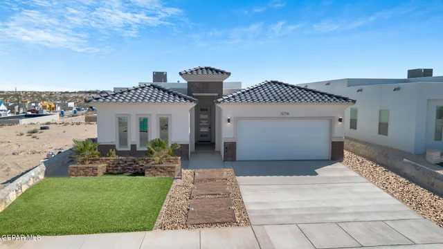 a front view of a house with a garden and pathway