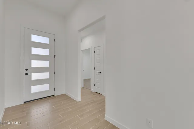 a view of an empty room with closet and wooden door
