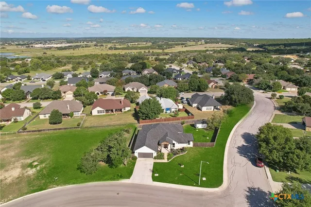 an aerial view of residential houses with outdoor space and ocean view