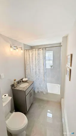 a bathroom with a granite countertop sink toilet and shower